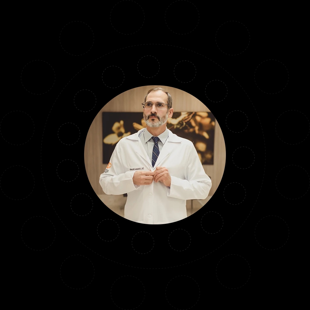 Dr. Antônio Brunetto Neto de jaleco em seu consultório